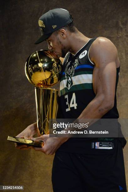 Giannis Antetokounmpo of the Milwaukee Bucks poses for a photo while holding the Larry O'Brien Trophy after defeating the Phoenix Suns in Game Six to...