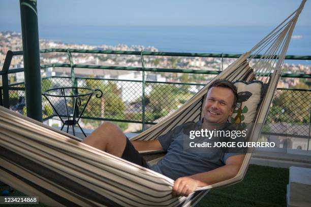 British expat Mike Battle rests in a hammock at home in Malaga on July 21, 2021. - Tens of thousands of expats are separated from friends and family...