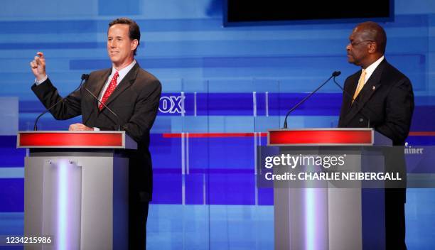 Republican presidential candidates former Pennsylvania Sen. Rick Santorum and businessman Herman Cain are pictured during the Iowa GOP/Fox News...