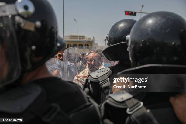 Supporter of the Islamist party Ennahdha faces the riot police during a sit-in protest led by the Tunisian Parliament Speaker Rached Ghannouchi, in...