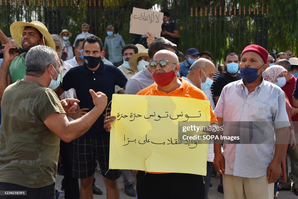 Tunisian protester holds a placard with slogans denouncing...