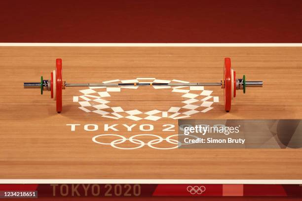 Women's Weightlifting: 2020 Summer Olympics: View of dumbell bar with weights sitting over Tokyo 2020 Olympics logo during 49Kg Qualify at Tokyo...