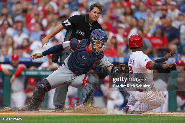 Jean Segura of the Philadelphia Phillies is tagged out by catcher Tres Barrera of the Washington Nationals on a fly ball hit by Rhys Hoskins during...