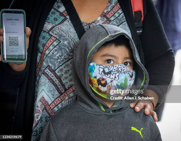 Los Angeles, CA First grade student Daniel Cano right, with his mom, Sonia Cano, listen to Josefina Flores, not pictured, principal, talk about...