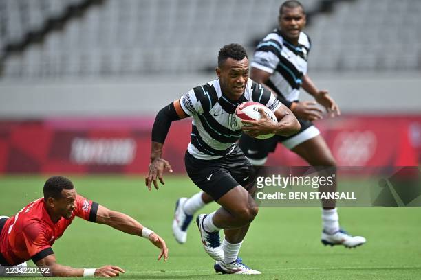 Fiji's Sireli Maqala avoids the tackle of Britain's Dan Norton in the men's pool B rugby sevens match between Fiji and Britain during the Tokyo 2020...