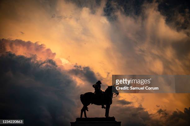 Statue of former U.S. President Ulysses S. Grant is silhouetted by the sunset after a heavy thunderstorm blew through the area on Capitol Hill on...
