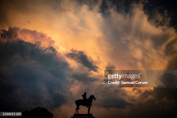 Statue of former U.S. President Ulysses S. Grant is silhouetted by the sunset after a heavy thunderstorm blew through the area on Capitol Hill on...