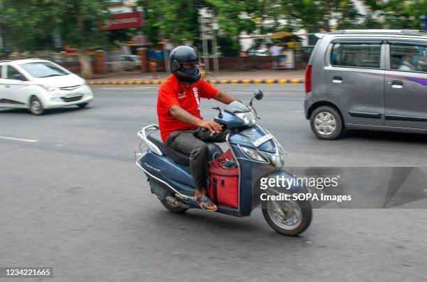 Zomato delivery man in rush hour on road going for food delivery at Connaught Place. Zomato is an Indian multinational restaurant aggregator and food...