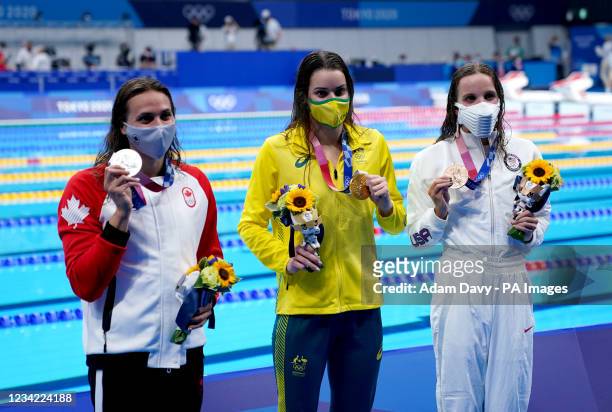 Australia's Kaylee McKeown with her gold medal after winning the Women's 100m Backstroke Final alongside Canada's Kylie Masse with her silver medal...