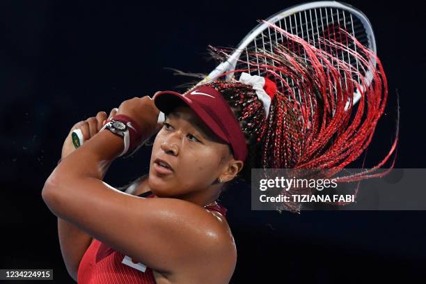 Japan's Naomi Osaka returns the ball to Czech Republic's Marketa Vondrousova during their Tokyo 2020 Olympic Games women's singles third round tennis...