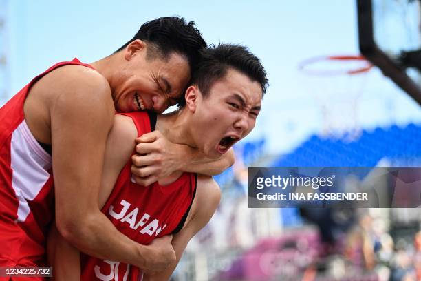 Japan's Keisei Tominaga and Japan's Tomoya Ochiai celebrate after wining at the end of the men's first round 3x3 basketball match between China and...