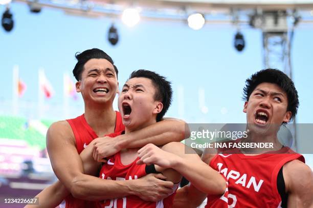 Japan's Tomoya Ochiai, Japan's Keisei Tominaga and Japan's Ryuto Yasuoka celebrate after wining at the end of the men's first round 3x3 basketball...