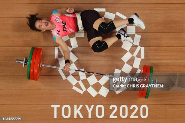 This picture taken with a robotic camera shows Taiwan's Kuo Hsing-chun reacting after winning the gold medal in the women's 59kg weightlifting...