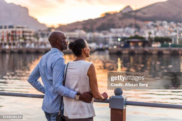 couple looking at sunset at cape town waterfront - città del capo foto e immagini stock