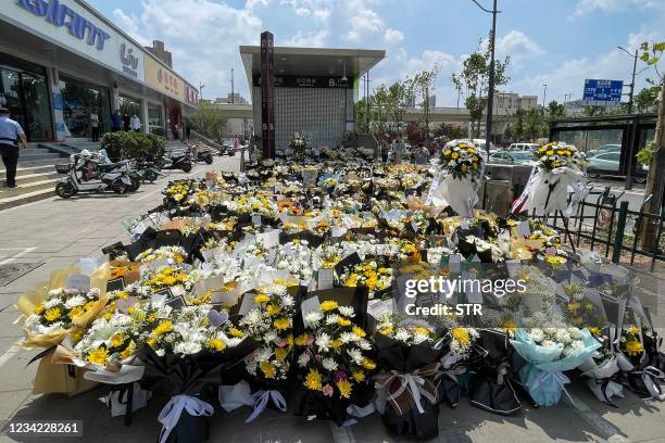 Flowers placed as tributes are seen in front of a subway station in memory of flood victims in Zhengzhou, China's central Henan province on July 27,...