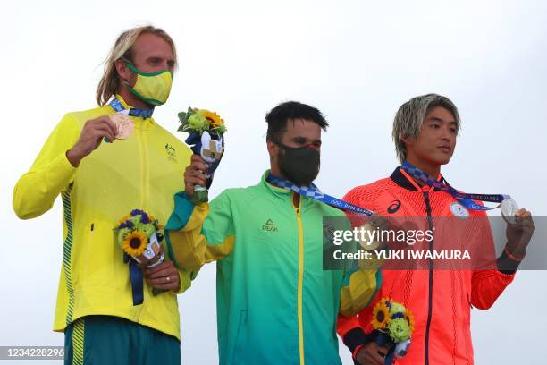 Bronze medalist Australia's Owen Wright, gold medalist Brazil's Italo Ferreira and silver medalist Japan's Kanoa Igarashi celebrate on the podium...