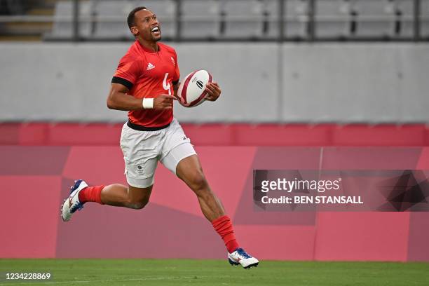 Britain's Dan Norton scores a try in the men's quarter-final rugby sevens match between Britain and the US during the Tokyo 2020 Olympic Games at the...