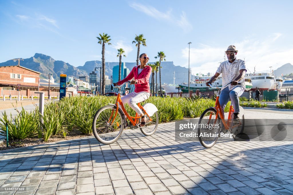 Couple sightseeing on hired bicycles in city