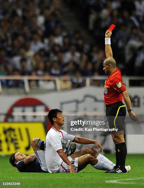 Referee Ali Hamad Albadwawi shows the red card to Jong Il Gwan of North Korea after tackling to Yasuhito Endo of Japan during the 2014 FIFA World Cup...