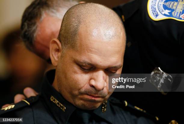 Metropolitan Police Officer Michael Fanone comforts U.S. Capitol Police sergeant Aquilino Gonell as he's seated to testify before the opening hearing...