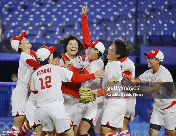 Japanese pitcher Yukiko Ueno celebrates with teammates after a 2-0 win over the United States in the gold medal game of the Tokyo Olympic softball...