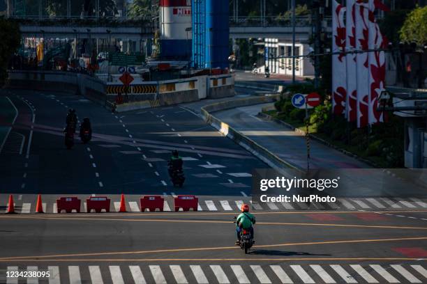 Motorcyclists try to pass a road block in Jakarta on 27 July 2021. Jakarta governor Anies Baswedan on Tuesday said the public activity restriction...