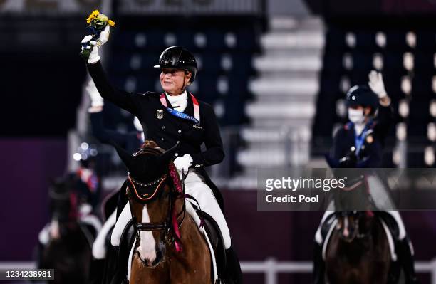 Gold medallist Isabell Werth of Germany rides on her horse together with other medallists after the medal ceremony on day four of the Tokyo 2020...