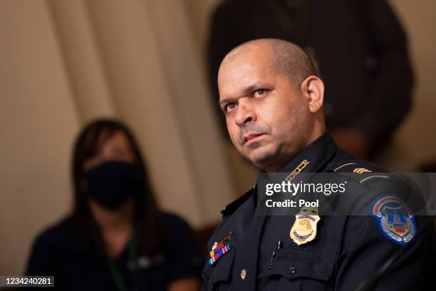 Aquilino Gonell, sergeant of the U.S. Capitol Police, watches a video of rioters during a hearing of the House select committee investigating the...