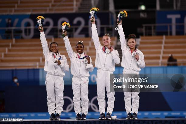 Silver medalists USA's Sunisa Lee, USA's Grace Mc Callum USA's Simone Biles and USA's Jordan Chiles wave on the podium of the artistic gymnastics...