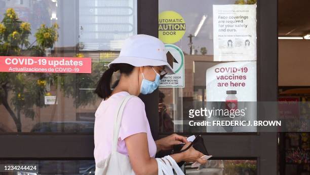 Woman enters a CVS drugstore in Monterey Park, California, where Covid-19 vaccines are being offered on July 27, 2021. - Los Angeles County is seeing...