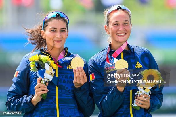 Gold medallists Romania's Ancuta Bodnar and Simona Radis celebrate on the podium following the women's double sculls final during the Tokyo 2020...