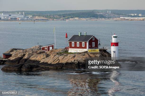 Lighthouse and red house on rocky island on Archipelago of Gothenburg. With four Ro-Ro terminals, the Port of Gothenburg is equipped to handle all...