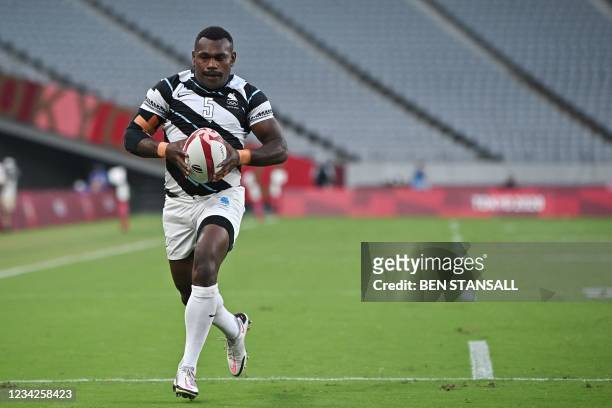 Fiji's Asaeli Tuivuaka runs to score a try in the men's final rugby sevens match between New Zealand and Fiji during the Tokyo 2020 Olympic Games at...