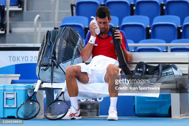 Novak Djokovic tries to keep cool in the blistering heat during the Men's Tennis Round 3 match between Novak Djokovic of Serbia and Alejandro...