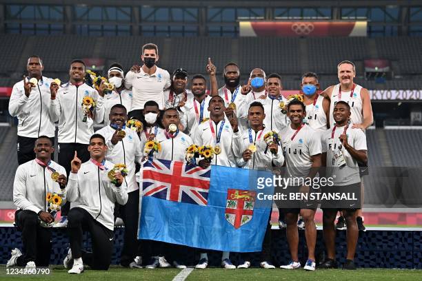 Fiji's players celebrate with their gold medals while standing on the podium after the victory ceremony following the men's final rugby sevens match...