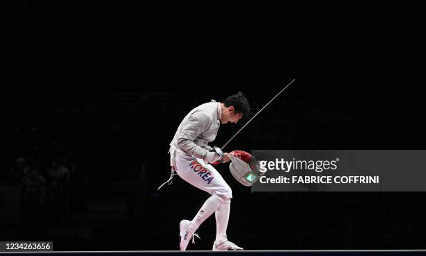 South Korea's Gu Bongil celebrates scoring a point against Italy's Aldo Montano in the men's sabre team gold medal bout during the Tokyo 2020 Olympic...