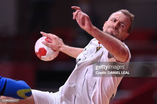 Germany's left back Julius Kuhn shoots to score during the men's preliminary round group A handball match between France and Germany of the Tokyo...