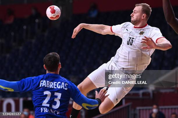 Germany's left back Julius Kuhn passes the ball during the men's preliminary round group A handball match between France and Germany of the Tokyo...