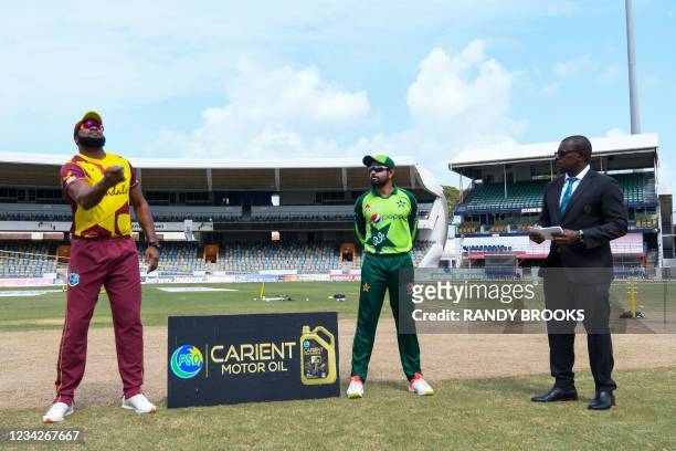 Kieron Pollard of West Indies tosses the coin as Babar Azam and match referee Sir Richie Richardson look on during the 1st T20I between West Indies...
