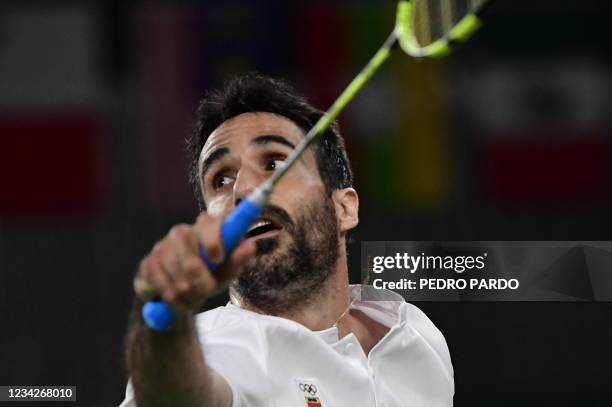 Spain's Pablo Abian hits a shot to China's Chen Long in their men's singles badminton group stage match during the Tokyo 2020 Olympic Games at the...