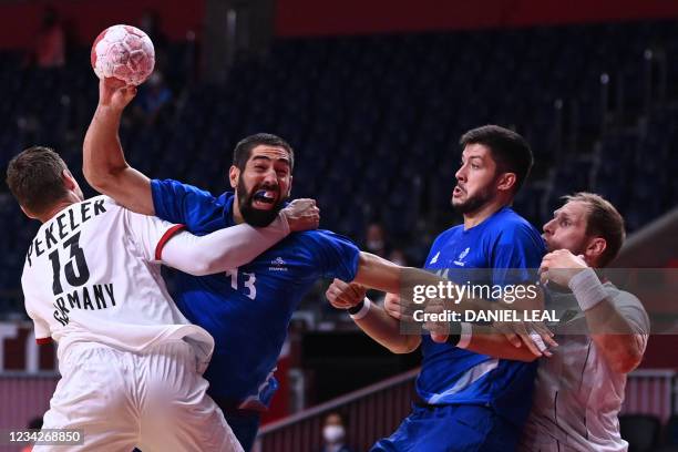 France's centre back Nikola Karabatic is challenged during the men's preliminary round group A handball match between France and Germany of the Tokyo...