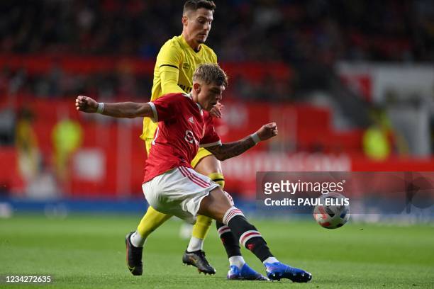 Brentford's Spanish striker Sergi Canos vies with Manchester United's English defender Brandon Williams during the English Premier League friendly...