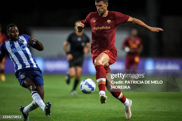 Roma's Bosnian forward Edin Dzeko challenges Porto's Portuguese defender Wilson Manafa during a friendly football match between AS Roma and FC Porto...