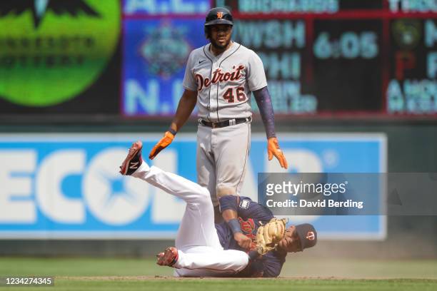 Jeimer Candelario of the Detroit Tigers looks on after hitting an RBI double while Jorge Polanco of the Minnesota Twins reacts after fielding the...