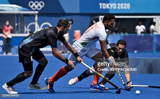 India's Harmanpreet Singh is tackled by Argentina's Nahuel Salis and Agustin Alejandro Mazzilli during their men's pool A match of the Tokyo 2020...