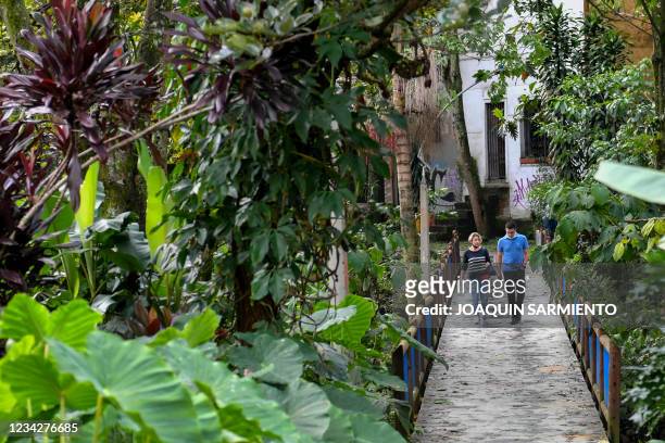 People walk on a bridge at a green corridor in Poblado neighborhood in Medellin, Colombia, on June 13, 2021. - The city of Medellin has been awarded...