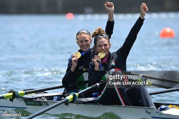 Gold medallists Italy's Valentina Rodini and Federica Cesarini pose in their boat following the lightweight women's double sculls final during the...