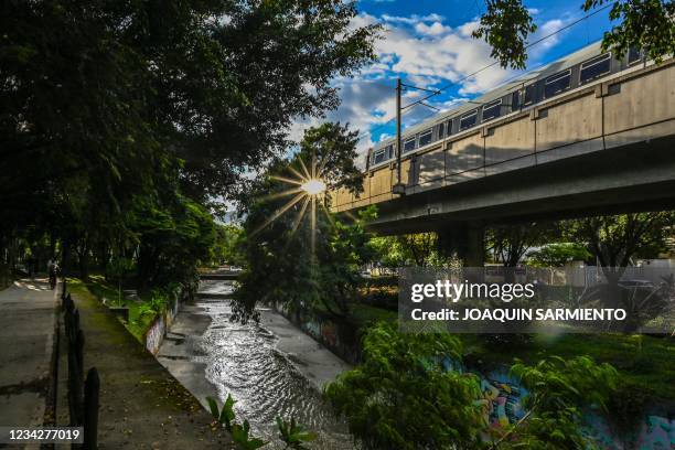 The metro passes by a green corridor in Medellin, Colombia, on June 15, 2021. - The city of Medellin has been awarded and recognized for its urban...