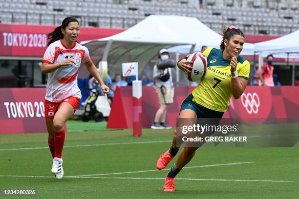 Australia's Charlotte Caslick runs in for a try during the women's pool C rugby sevens match between Australia and Japan during the Tokyo 2020...