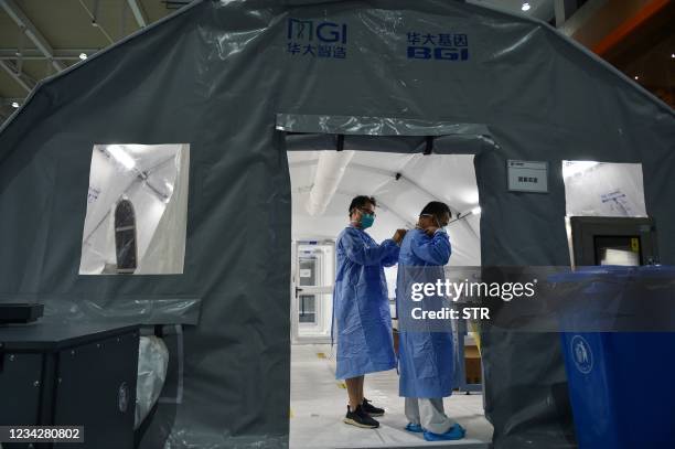 This photo taken on July 28, 2021 shows staff members wearing protective gear at a temporary "Fire Eye" laboratory used for Covid-19 coronavirus...